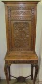 A 19th century oak side cabinet on stand, with carved panel door,