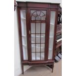 A 20th century mahogany standing corner cupboard with a glazed door and glazed sides