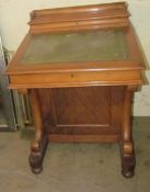 A Victorian walnut Davenport with a raised stationery compartment, sloping fall,