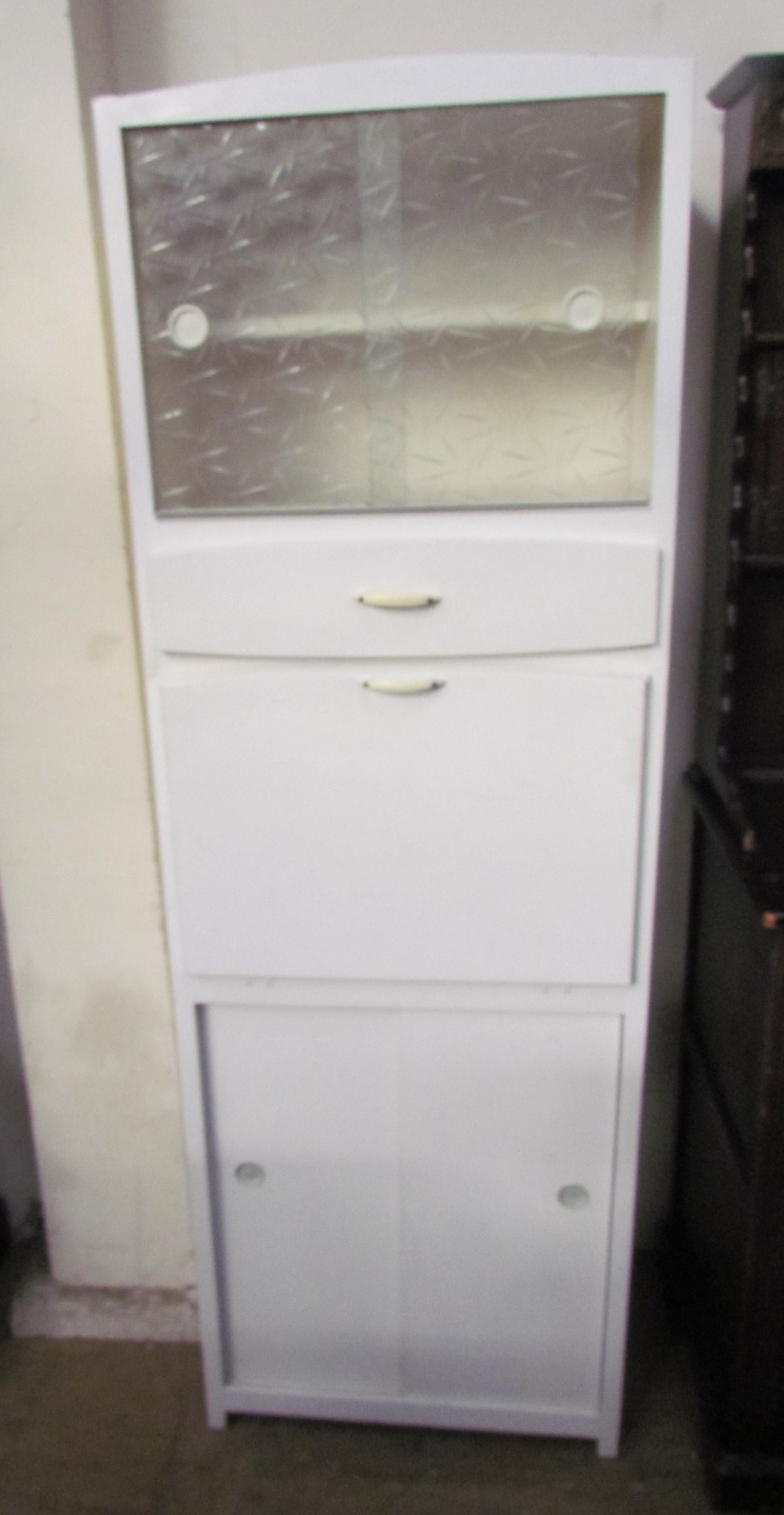 A white painted kitchen cabinet, with a pair of glazed sliding doors, a drawer,