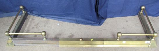An expandable brass fire fender, with ball finials and bars