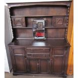 A 20th century oak dresser with a shelved and cupboard top, the base with drawers and cupboards