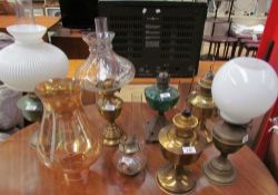 A collection of brass oil lamps together with other oil lamps