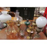 A collection of brass oil lamps together with other oil lamps