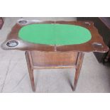 An oak games table, with a foldover top, oval baize interior and counter well,