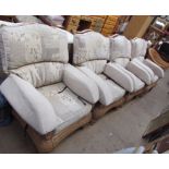A set of four conservatory armchairs with floral upholstery and another wicker armchair