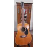 A Sagadia model 9204S twelve string acoustic guitar on a stand