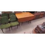 A mid 20th century teak extending dining table together with a set of four upholstered dining chairs
