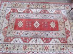 A room size orange ground rug with an orange centre, cream borders and guard stripes