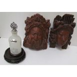 A pair of Balinese carved masks and a glass and white metal bottle