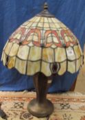 A Tiffany style table lamp, with a leaded glass shade on a baluster column and spreading base