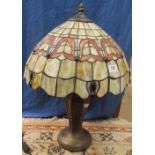 A Tiffany style table lamp, with a leaded glass shade on a baluster column and spreading base