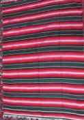 A Mexican rug with multiple coloured stripes together with other Mexican rugs