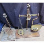 A brass balance scales with some weights together with a Dental press base