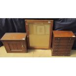 A table top chest with six graduated drawers on a plinth base together with a wall mounted cabinet