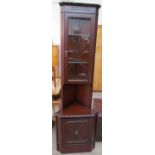 A reproduction mahogany standing corner cupboard with a glazed top and cupboard base