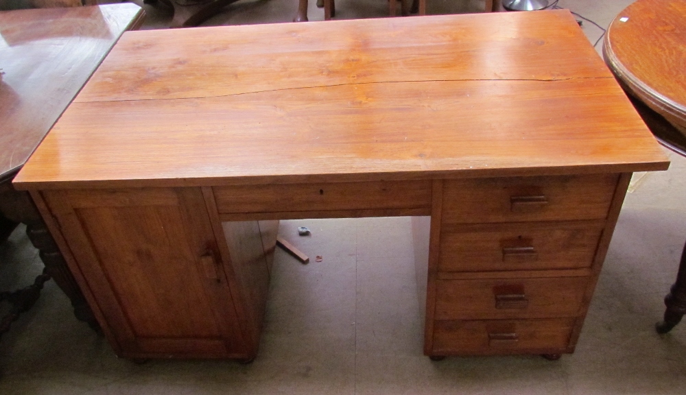 A 20th century walnut desk with a rectangular top above a central drawer, with a cupboard to one