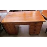 A 20th century walnut desk with a rectangular top above a central drawer, with a cupboard to one