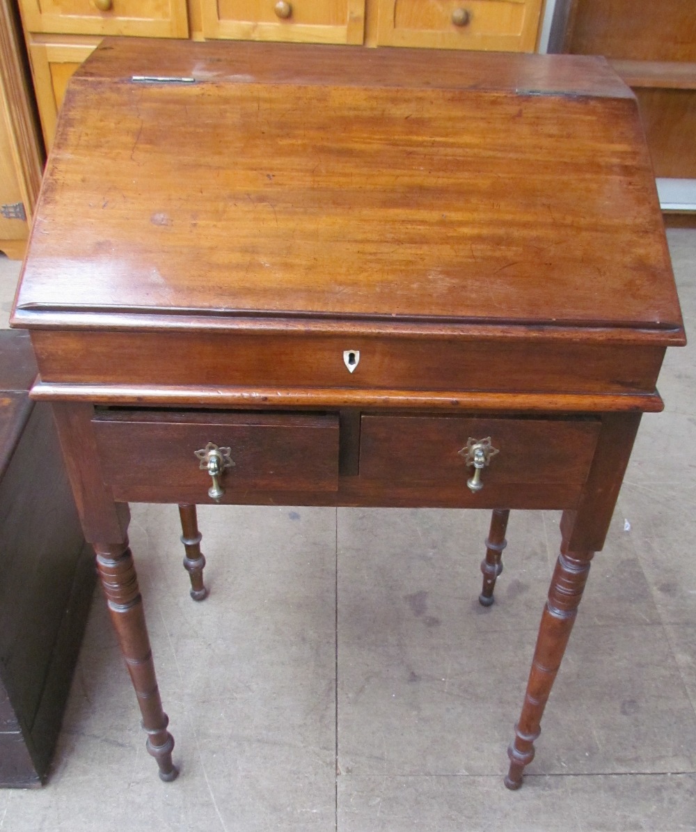 A 19th century mahogany bureau, with a sloping fall above two drawers on turned tapering legs