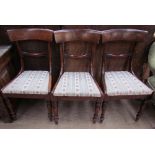 A set of three Regency mahogany dining chairs with an outswept top rail with a bar back and drop