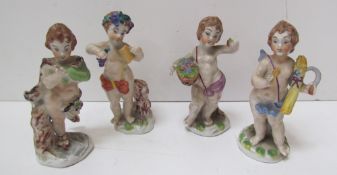 A set of four porcelain cherubs depicting the four seasons