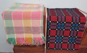 A Welsh blanket with a black ground and geometric pattern together with another Welsh blanket