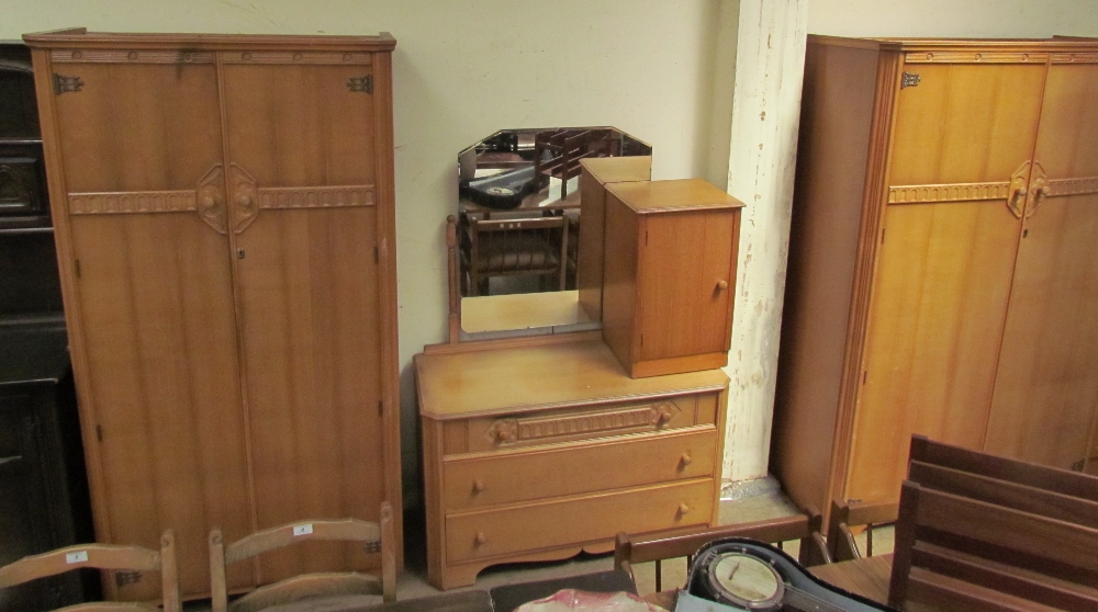 A 20th century oak bedroom suite comprising two wardrobes, dressing table and bedside cabinet