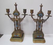A pair of gilt and enamel decorated candelabra, with twin branches on stepped square base