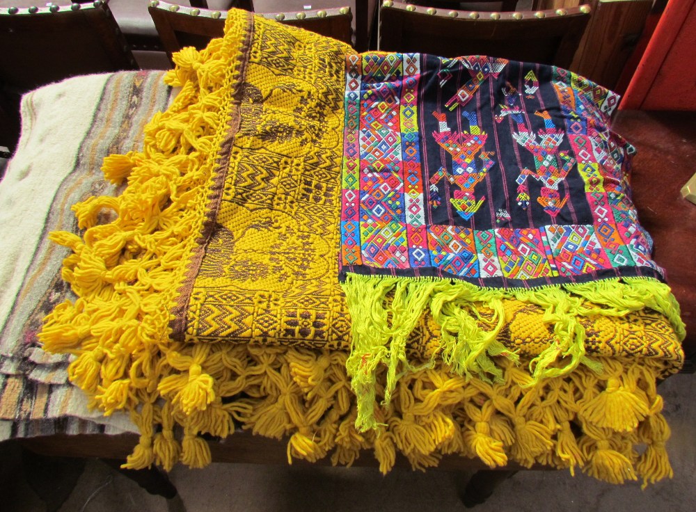 A large collection of Mexican fabrics including blankets, table coverings, cushion covers etc