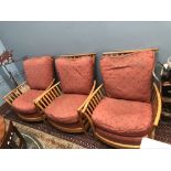 A set of three light elm Ercol elbow chairs with pad upholstered seats and back