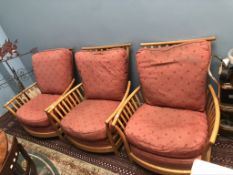 A set of three light elm Ercol elbow chairs with pad upholstered seats and back