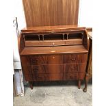 A reproduction mahogany cylinder bureau with three graduated drawers