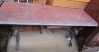 A mahogany table on a cast iron base decorated with winged figure "Salve"