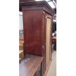 A Victorian mahogany wardrobe with a moulded cornice above a single door on a plinth base