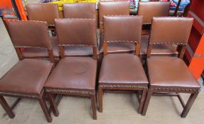 A set of eight oak dining chairs with brown leatherette coverings