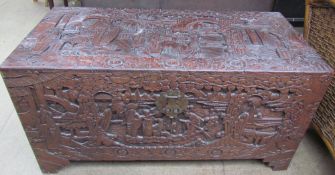 A Chinese carved camphor wood coffer decorated with figures and trees