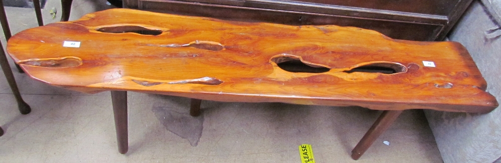 A yew coffee table of irregular shape on four tapering legs