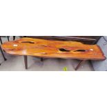 A yew coffee table of irregular shape on four tapering legs