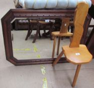 An oak framed wall mirror together with an elm seated three legged back stool