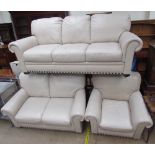 A cream leather three piece suite comprising a three seater settee,