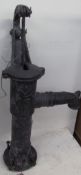 A cast iron water pump together with a floor vase