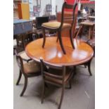 A reproduction mahogany extending dining table together with an additional leaf and five Regency