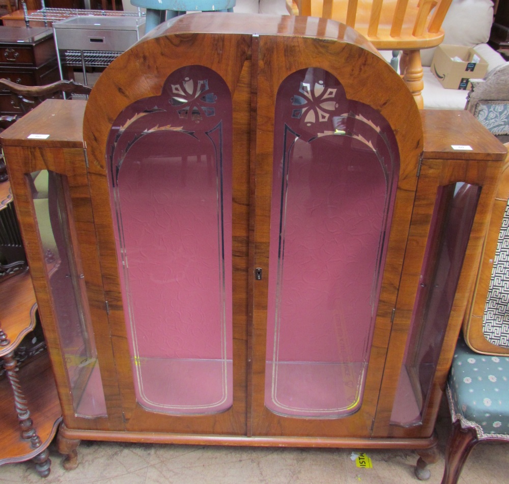 A 20th century walnut display cabinet with a domed top and a pair of silvered glass doors on