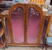 A 20th century walnut display cabinet with a domed top and a pair of silvered glass doors on