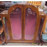 A 20th century walnut display cabinet with a domed top and a pair of silvered glass doors on