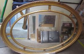 A 19th century gilt gesso wall mirror of oval form with a gadrooned rim and reeded inner oval