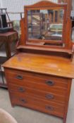 An Edwardian satin walnut dressing table with a rectangular mirror above three long drawers on