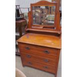 An Edwardian satin walnut dressing table with a rectangular mirror above three long drawers on