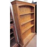 A 20th century pine bookcase with a moulded cornice and four shelves on a plinth base