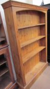 A 20th century pine bookcase with a moulded cornice and four shelves on a plinth base